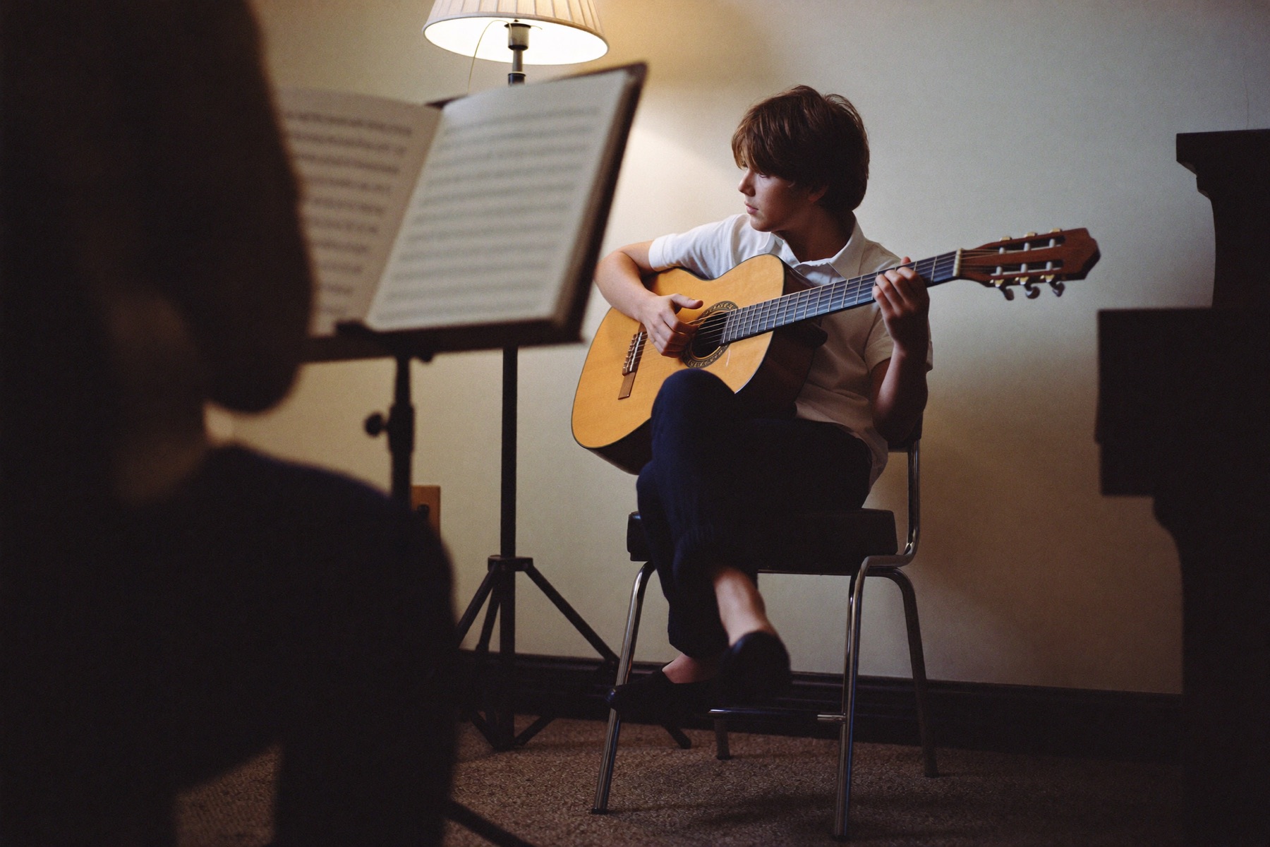 Student reading sheet music during a classical guitar lesson at Musical Moments