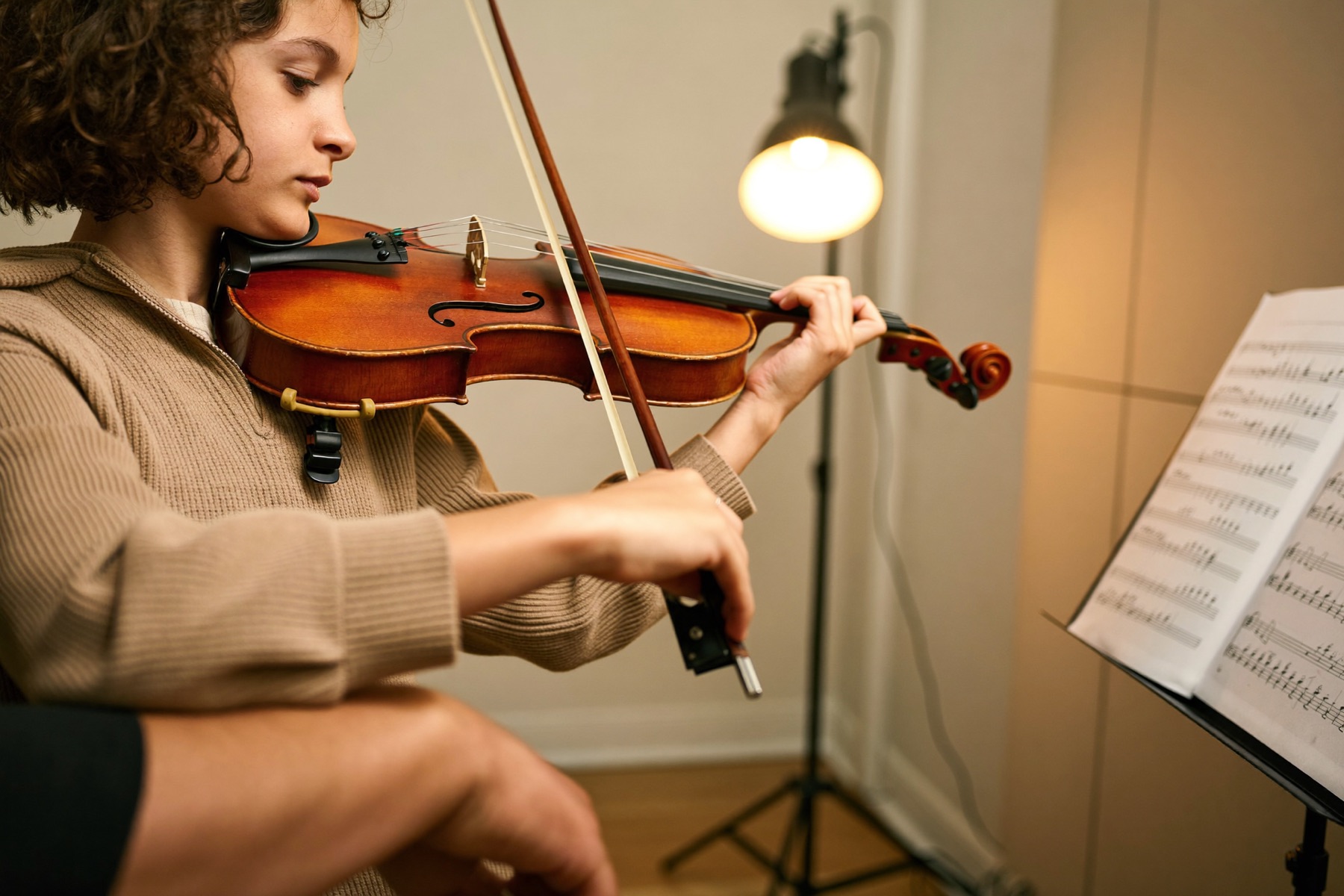 Child learning violin bow technique with a teacher at Musical Moments Music Studio